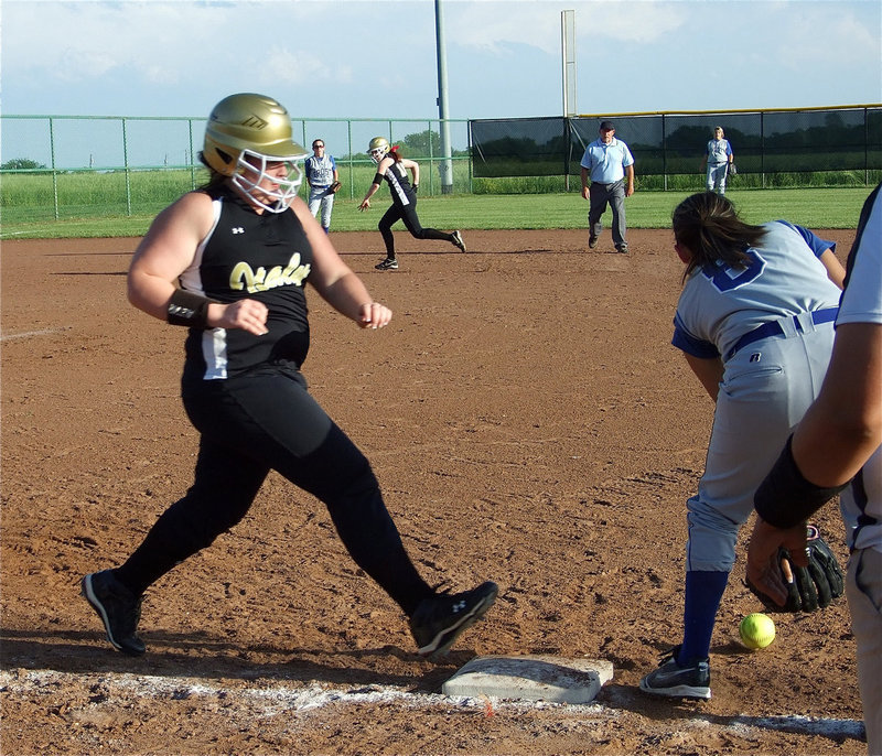 Image: One-One is on. — Senior Meredith Brummett(11) beats the throw to first base for a single.