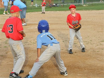 Image: I dare you — With his rally cap flipped up, Reese Janek dares a Milford runner to try for second while Janek’s teammate, Cornelius Jones, waits for the throw.