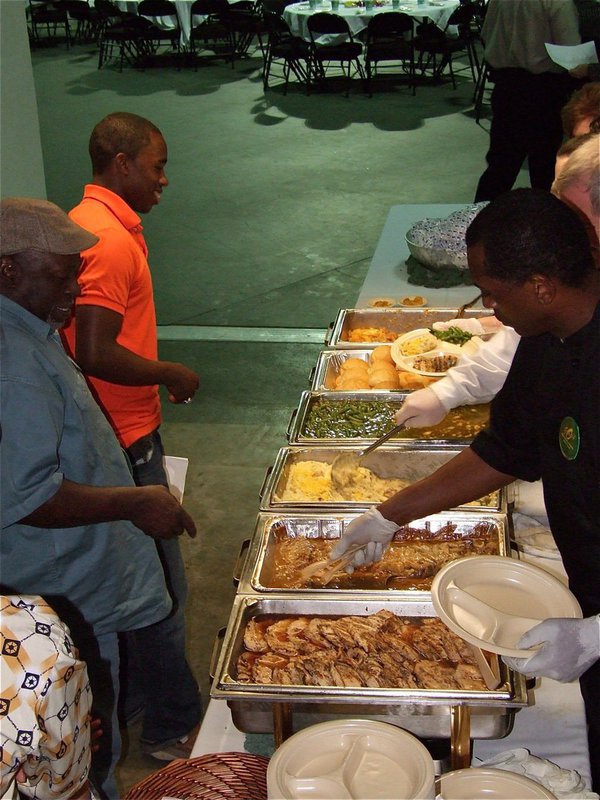 Image: Let’s eat! — Jasenio Anderson and his father, Willie Henderson, receive their entrees upon entering the FCA All-Star Victory Banquet inside Paul J. Meyer Arena.