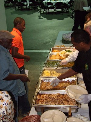Image: Let’s eat! — Jasenio Anderson and his father, Willie Henderson, receive their entrees upon entering the FCA All-Star Victory Banquet inside Paul J. Meyer Arena.
