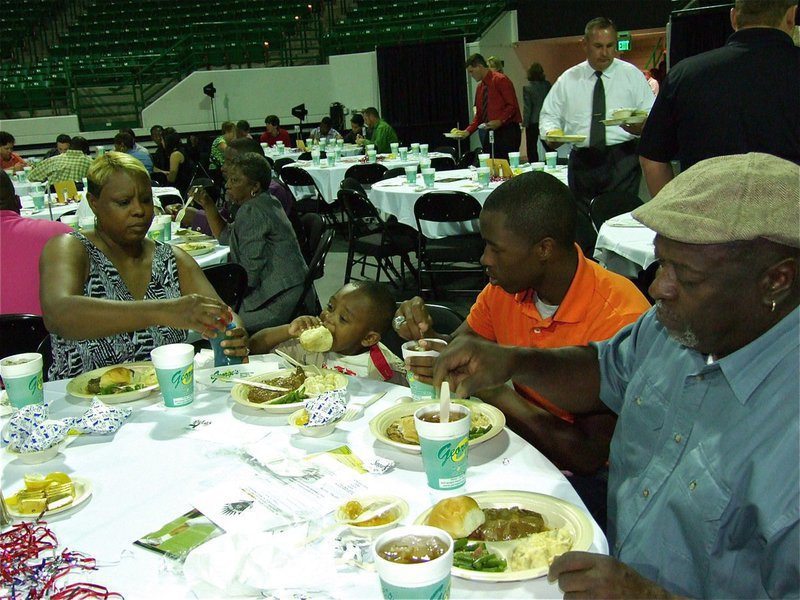 Image: Proud nephew — Jasenio Anderson checks on his nephew, Ty Anderson, who desperately wants to follow in his uncle’s cleat steps, one biscuit at a time.