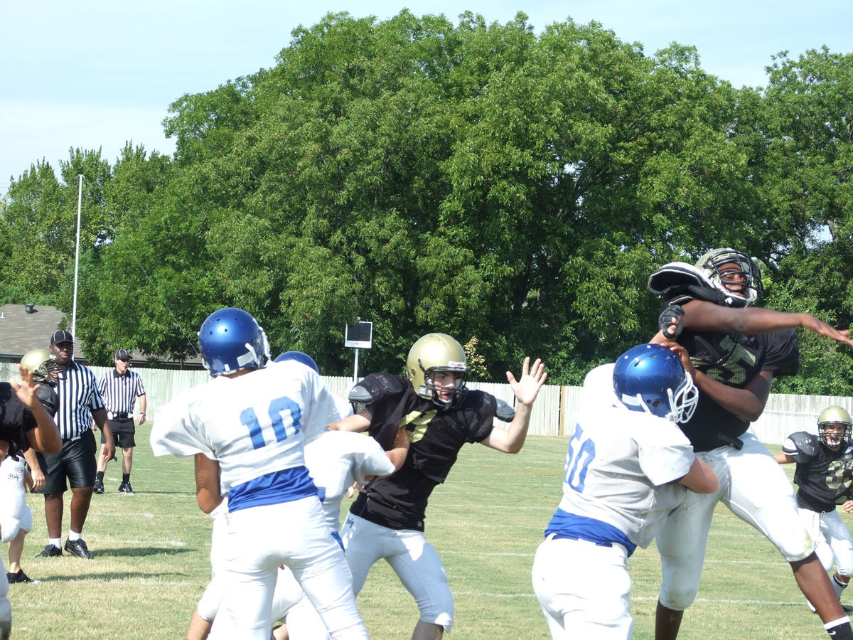Image: Big swat — Lil’ Larry Mayberry tries to swat the ball back into the Blooming Grove quarterback’s facemask.