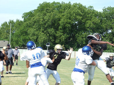 Image: Big swat — Lil’ Larry Mayberry tries to swat the ball back into the Blooming Grove quarterback’s facemask.