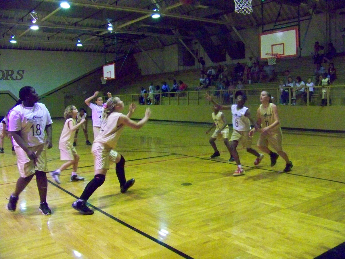 Image: Attacking the boards — Amber Hooker shoots a free shot while Jaclynn Lewis #22, Janae Robertson #8, Madison Washington #11 and Shercorya Chance #18 charge after the rebound.