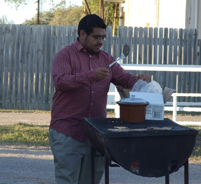 Image: Hamburger Time — The band members and parents sell concessions during the football games. Mr. Perez makes sure there are hamburgers to sell during the JV games.