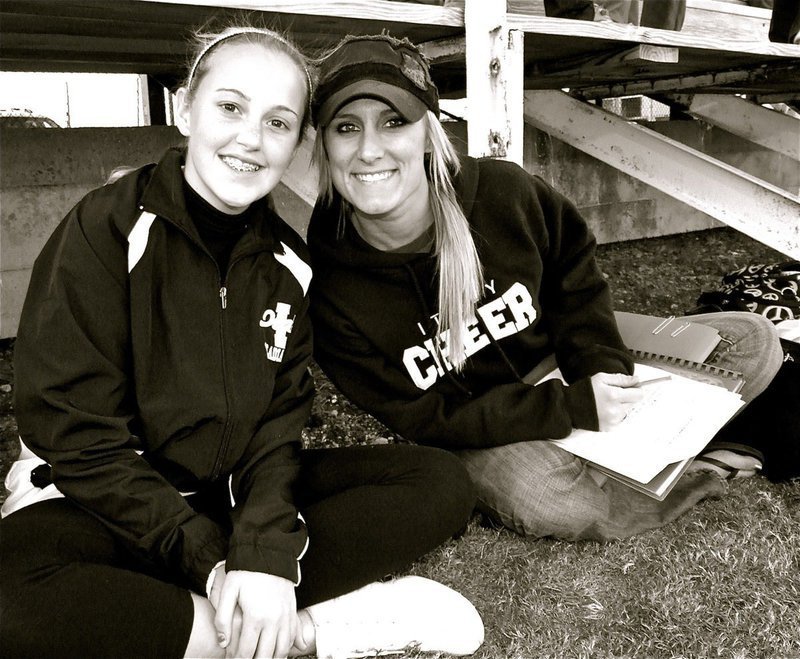 Image: Quiet time — Italy Junior High Cheerleader Kelsey Nelson and Cheerleading Advisor Amanda Patrick relax at the base of the bleachers during halftime.