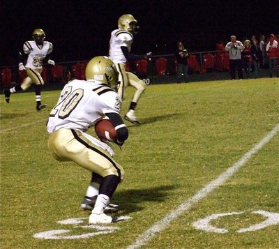 Image: Sephus returns — De’Andre Sephus(20) catches the kickoff and begins to run as Heath Clemons(2) and Corring Frazier(25) get in blocking position.