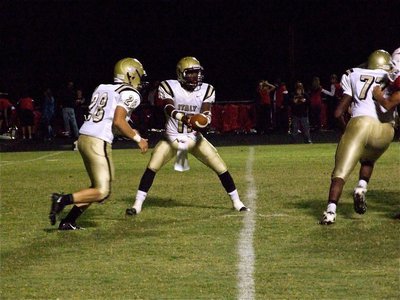 Image: Jasenio to Kyle — Kyle Jackson(28) prepares to take the handoff from Jasenio Anderson(11) and follow offensive lineman Larry Mayberry(77) thru the hole.