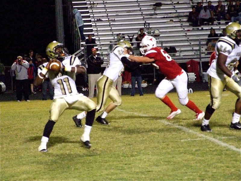 Image: The launch — Jasenio Anderson(11) is about to launch the deep ball as Brandon Souder(63) and Bobby Wilson(64) keep the Longhorns out of the passing pocket.