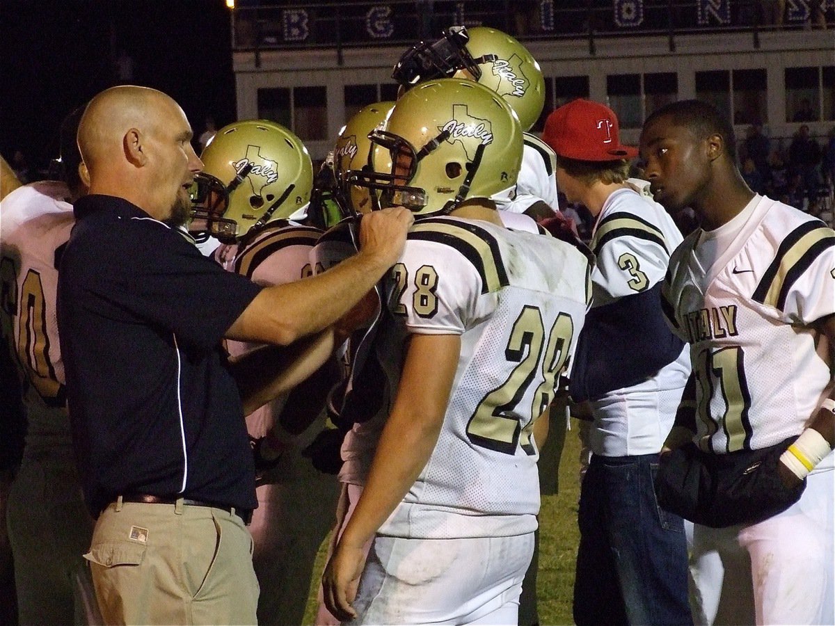 Image: Talking technique — Defensive Coach Jeff Richters talks technique with Kyle Jackson(28) as Jasenio Anderson(11) listens in.