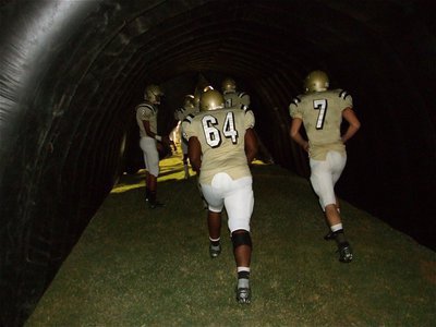 Image: Let’s go! — Eddie Garcia(8), Bobby Wilson(64), Kyle Wilkins(7) and their teammates run out of the Italy Gladiators’ tunnel to start the second half.