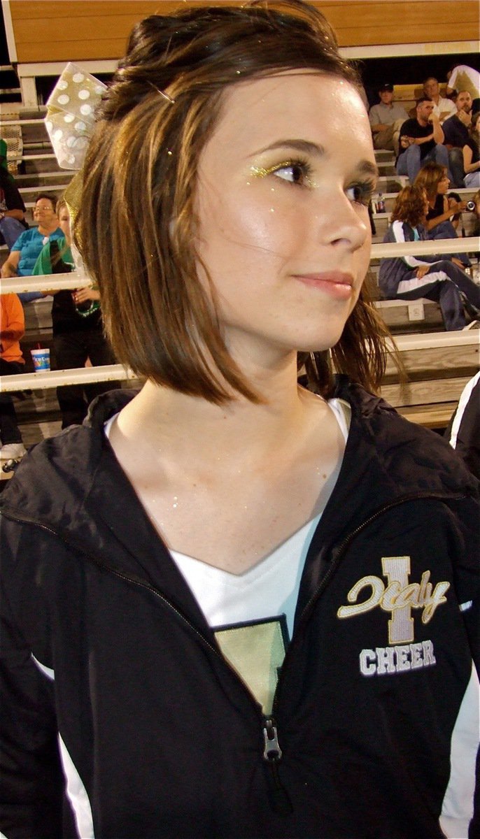 Image: Meagan looks on — IHS Cheerleader Meagan Hooker checks out the action on the field before performing a cheer.
