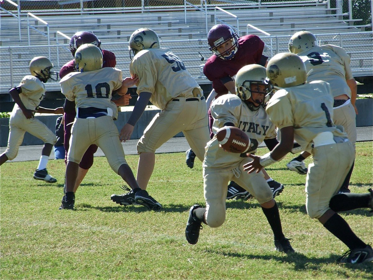 Image: Misdirection play — A-Team quarterback Tylan Wallace(2) hands off to Kendrick Norwood(1) who runs a reverse in the opposite direction.
