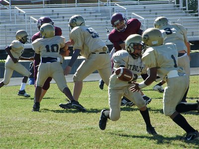 Image: Misdirection play — A-Team quarterback Tylan Wallace(2) hands off to Kendrick Norwood(1) who runs a reverse in the opposite direction.