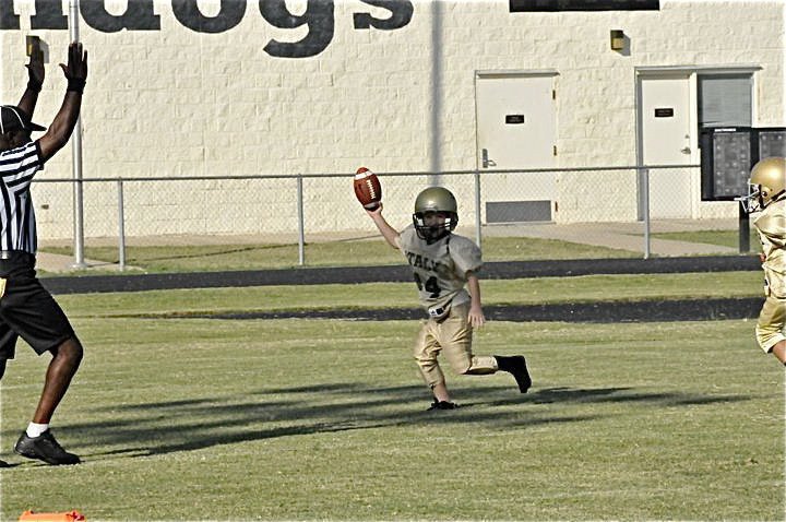 Image: Bryce DeBorde loses a shoe but the IYAA Bantams win first game — Bryce DeBorde raises the football in triumph after going the distance to help his Bantam teammates win their first game of the season 25-7 over the Palmer Bulldogs.