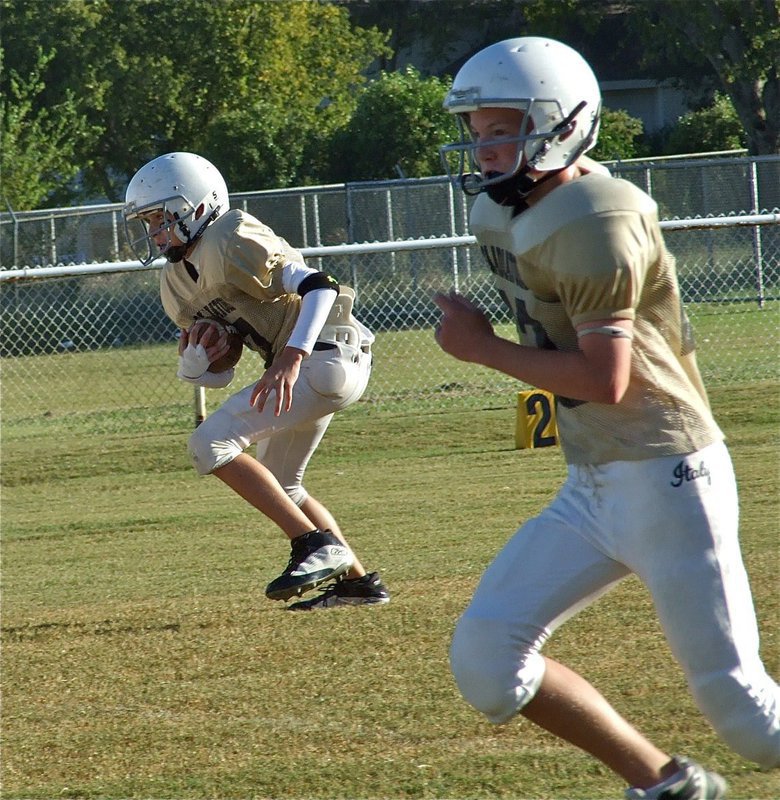 Image: On the move — Ryan Connor keeps the snap and heads upfield as slot receiver Cody Boyd(22) goes after a Bison to block.