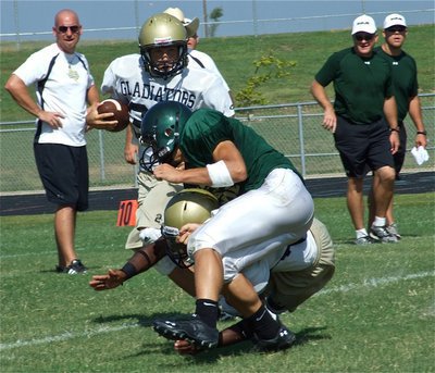 Image: Leading the way — Jasenio Anderson chops down an Eagle defender before Kyle Jackson(33) covered 65-yards for an apparent touchdown. Unfortunately, a clipping call on the Gladiators cancelled the effort.