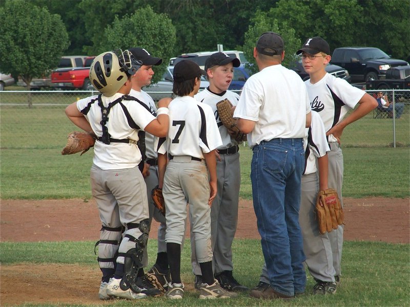 Image: Talking it over — Coach Jason Escamilla convenes with his 12u boys team in Whitney. (L-R): Catcher Tyler Fedrick, Kyle Fortenberry, Daren Cisneros, John Escamilla, head coach Jason Escamilla and first baseman Cody Boyd