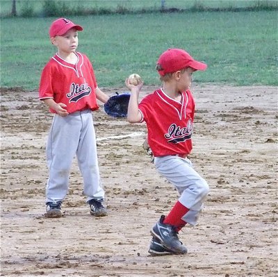 Image: Making the play — Jake Hamby looks on as Chase Hyles throws to first base to help earn a win that put the IYAA T-Ball boys team into the division tournament championship game.