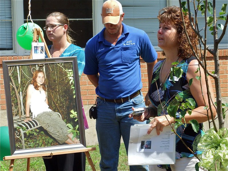 Image: Not forgotten — Standing with Shelley and her tree, Cynthia says some last words as the the dedication of Shelley’s Memorial Garden comes to a close.