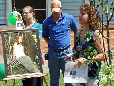 Image: Not forgotten — Standing with Shelley and her tree, Cynthia says some last words as the the dedication of Shelley’s Memorial Garden comes to a close.