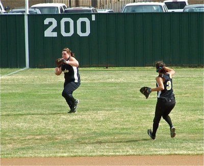 Image: Senior snag — Senior left fielder Meredith Brummett tracks down a fly ball to end the 4th inning as shortstop Anna Viers hustles in. Brummett also caught a fly ball for the first out in the top of the 7th inning to help seal the fate of the Meridian Lady Jackets.
