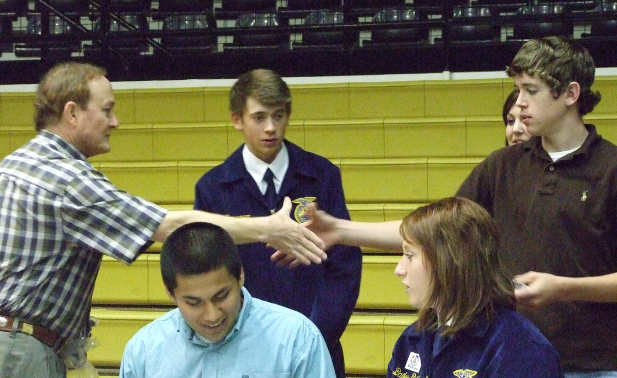 Image: Helpful hands — Sonny Dickerson congratulates Jon Walton on his officer renewal.