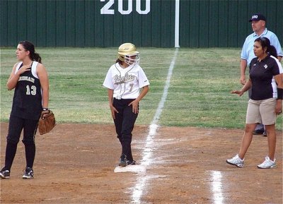 Image: Alma singles — Alma Suaste(7) gets coached up by Tina Richards after hitting one off the glove of Meridian’s pitcher.