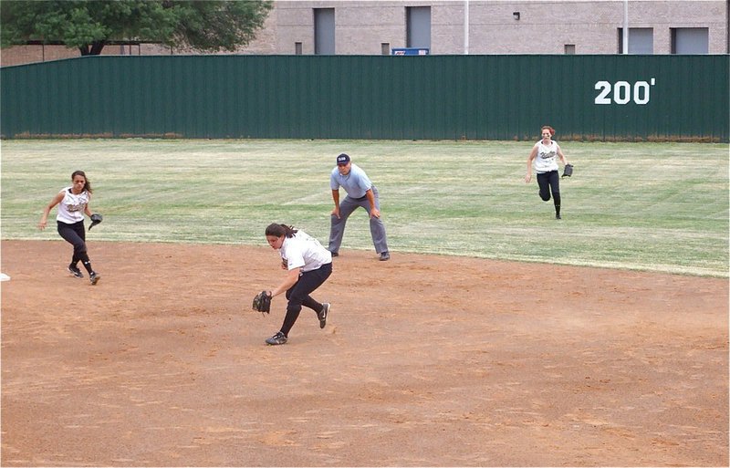 Image: Cori plays insane — Second baseman Cori Jeffords rushes up to catch a pop-up before it touches sand while teammates Anna Viers and Bailey Bumpus back Jeffords up. Jeffords also ended the game with a similar shoestring catch and finished with four caught fly balls.