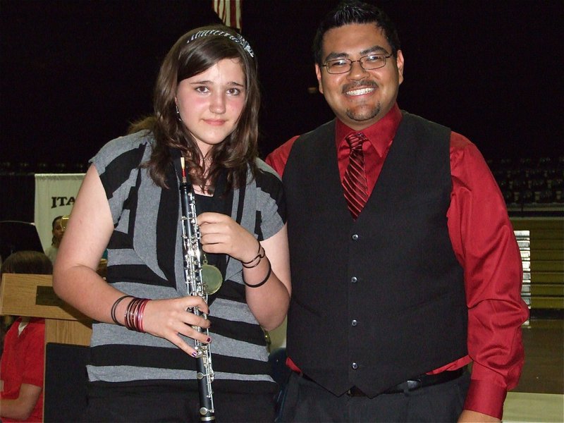 Image: Alexis & Mr. Perez — 7th grader Alexis Sampley, a 1st chair oboe player, receives a medal from IHS Band Director Jesus Perez.