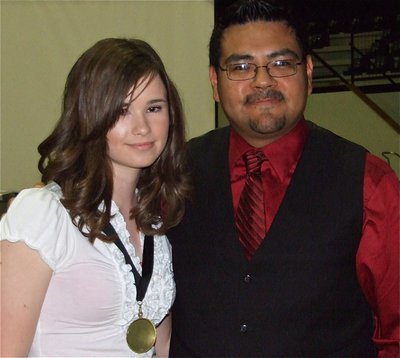 Image: Meagan honored — 8th grader Meagan Hooker receives a 1st chair medal from Jesus Perez. Hooker is a 1st chair flute, All-Region MS and Central Texas Honor Band member.