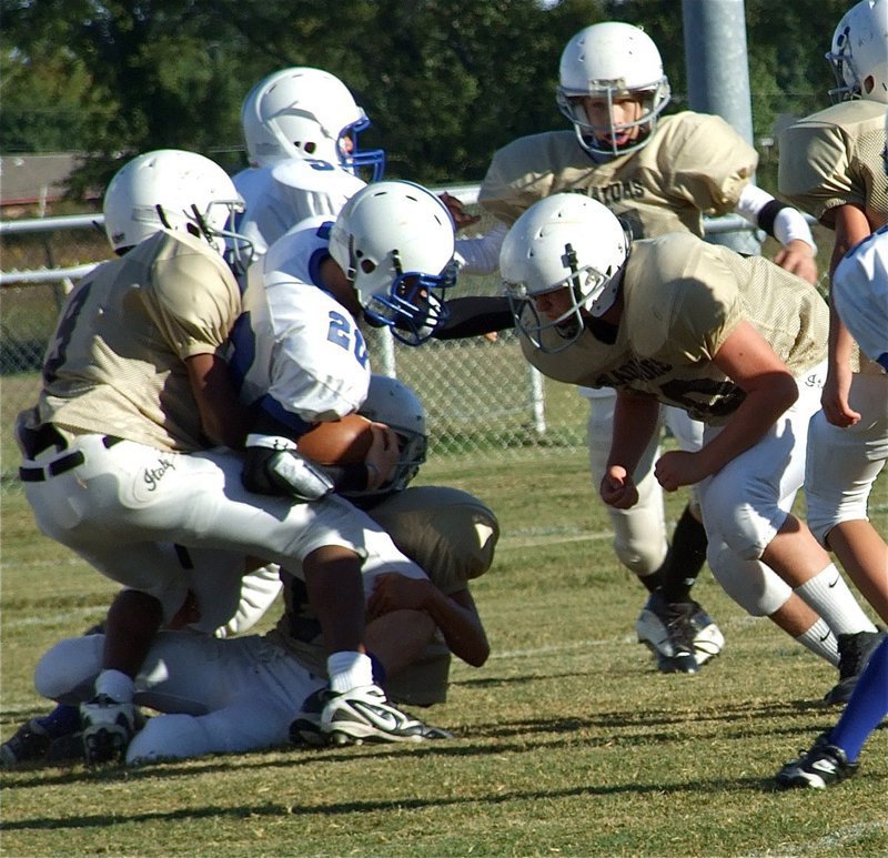 Image: Gladiators hang on to a Lion but Blooming Grove holds on for win — Italy’s JaRay Anderson(9), Colton Petrey(6) and Kyle Fortenberry(50) rough up a Blooming Grove Lion running back during solid performance by both Junior High squads. At the final buzzer, the Lions let out a roar after winning 14-0 at Willis Field in Italy.