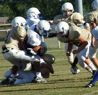 Image: Gladiators hang on to a Lion but Blooming Grove holds on for win — Italy’s JaRay Anderson(9), Colton Petrey(6) and Kyle Fortenberry(50) rough up a Blooming Grove Lion running back during solid performance by both Junior High squads. At the final buzzer, the Lions let out a roar after winning 14-0 at Willis Field in Italy.