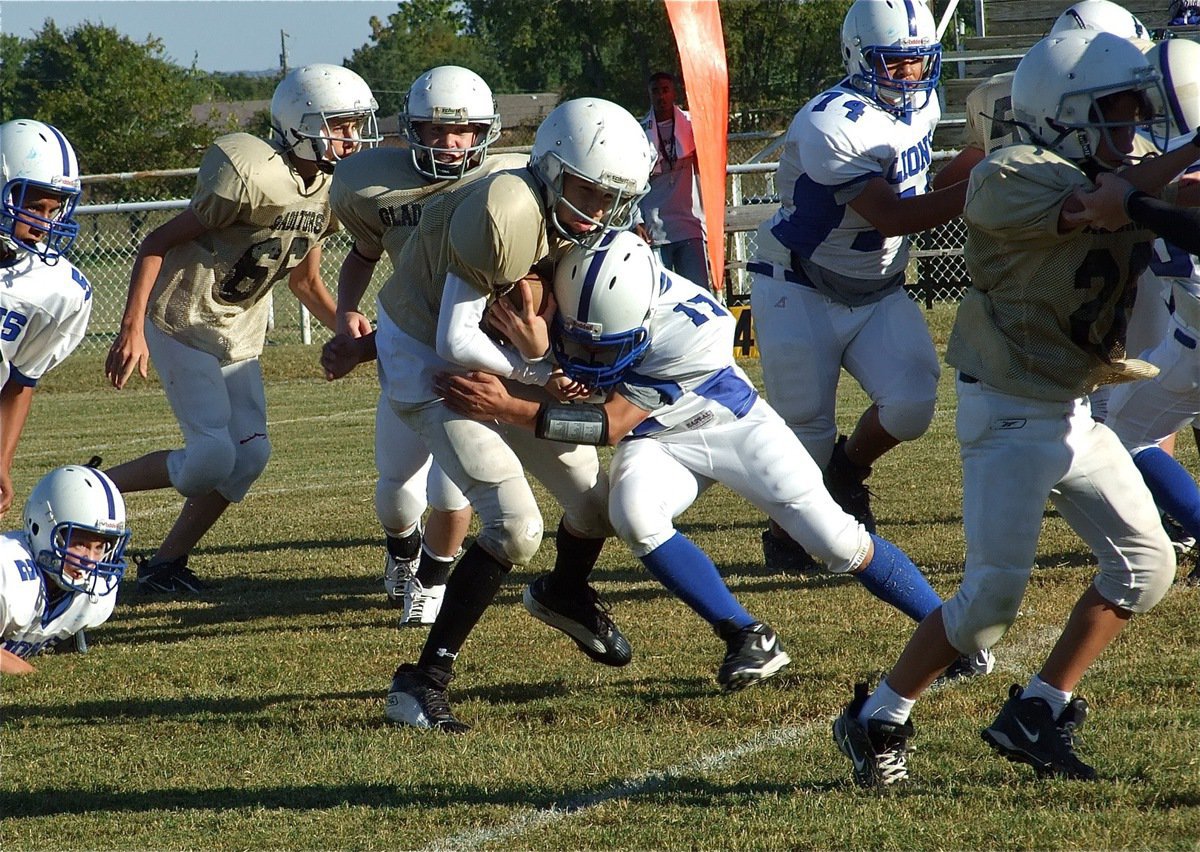 Image: The tough yards — Levi McBride(28) leads the way for JH Gladiator quarterback Ryan Connor.