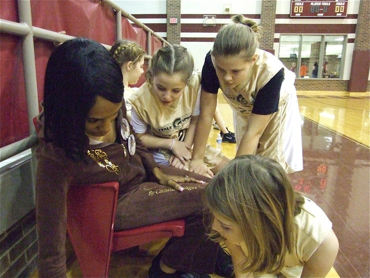 Image: Are we next? — Italy 24’s assistant coach Monica Lambert did a masterful job keeping track of the team’s 12 girl game rotation as Peyton Henderson, Lillie Perry and Halee Turner check to see who’s next.