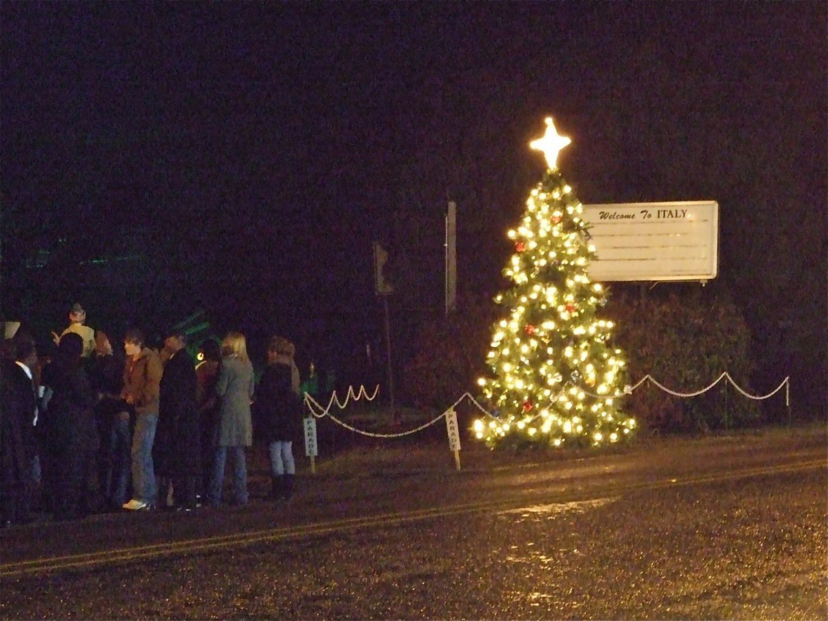 Image: The Christmas tree lights up Main Street in Italy — After the Christmas tree lights were turned on next to the marquee in downtown Italy, the congregation joined in the singing of Silent Night.