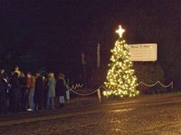 Image: The Christmas tree lights up Main Street in Italy — After the Christmas tree lights were turned on next to the marquee in downtown Italy, the congregation joined in the singing of Silent Night.