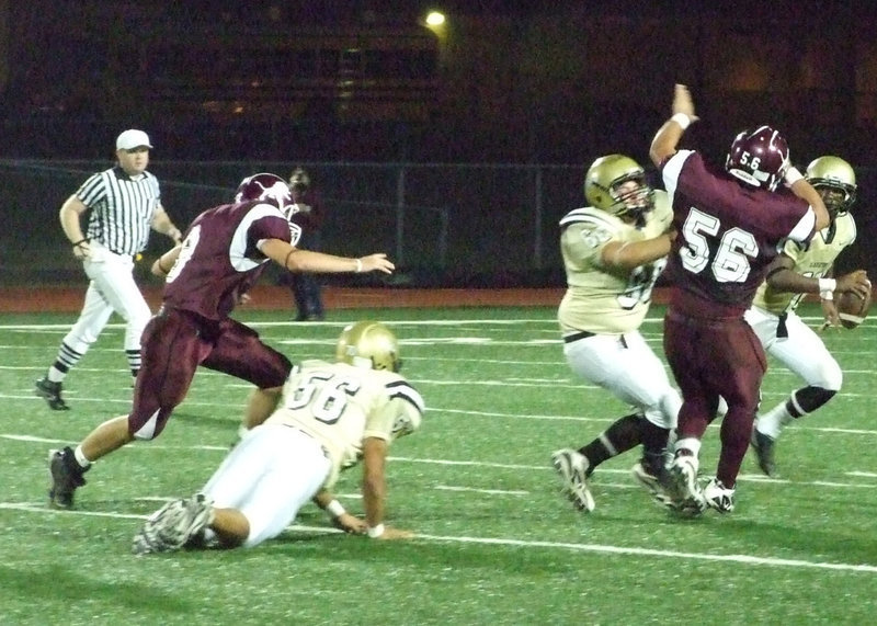 Image: Anderson to pass — Italy’s #60 Ivan Roldan tries to keep the Lion’s aggressive defensive line off of #11 Jasenio Anderson’s back.