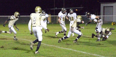 Image: Kick and catch — Desmond Anderson grabs a back leg of the Bulldog returner while Deandre Sephus(20), Aaron Thomas(9) and Heath Clemons(2) help bring him down.