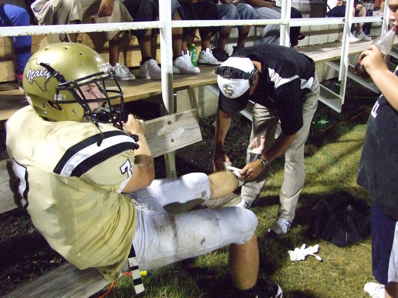 Image: Kyle and Kyle — Kyle Wilkins waits for Coach Kyle Holley to finish taping his ankle.
