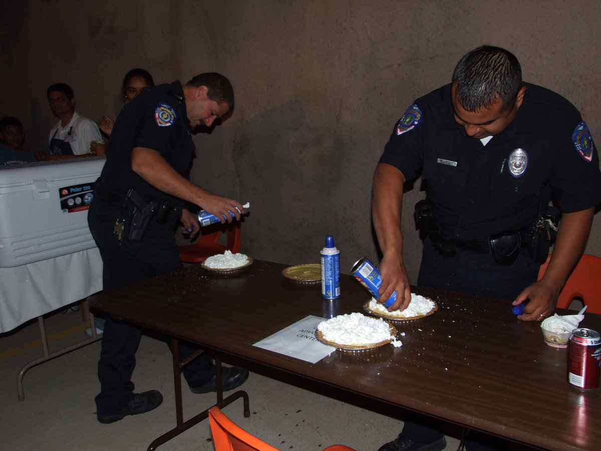 Image: Getting those pies ready — Chief Phoenix and officer Mannie Valdez getting the yummy pies ready for the pie eating contest.