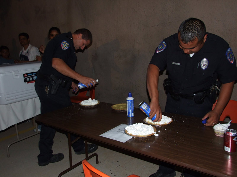 Image: Getting those pies ready — Chief Phoenix and officer Mannie Valdez getting the yummy pies ready for the pie eating contest.