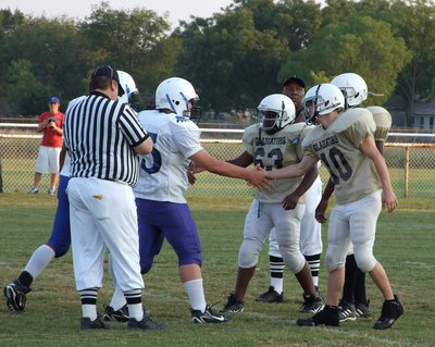 Image: 8th grade captains — #10 Chase Hamilton, #63 Adrian Reed and #25 Tyvion Copeland greet the Frost Polar Bears captains.