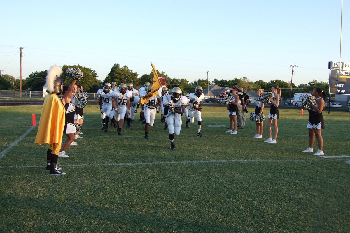Image: Gladiators come to battle — The cheerleaders and flag core line the field as the Gladiators run to their battle stations.
