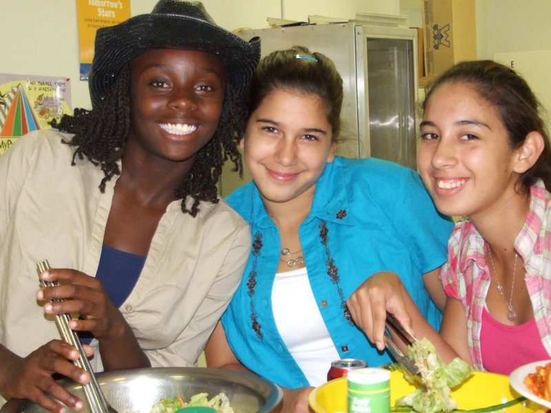 Image: Cheerleaders serving up dinner — Jalessa Hightower, Taylor Garza and Elizabeth Garza serving up dinner with a smile.