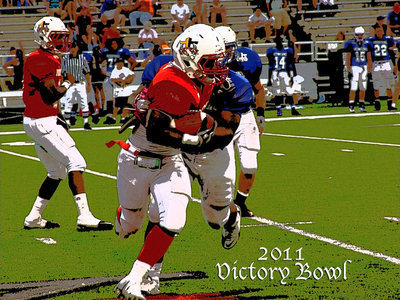 Image: Italy’s Jasenio Anderson(11) hands off to Dawson’s Alex Shaw(1), who tries to break away from Blue Team defenders during the 2011 Victory Bowl of consisting of senior All-Stars.