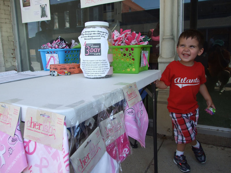 Image: Little 3 year old Gabriel Antunez is helping his mom at this booth. To help with the Susan G. Komen 3-Day Walk, Russell & Bridgette Coers and Mistiann Antunez each need $2300 to walk in November.