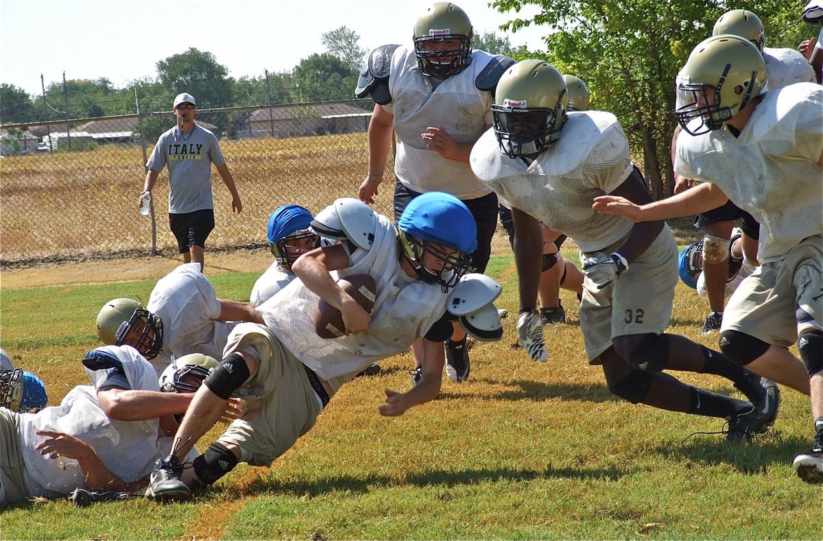 Image: From the inch line, Italy’s varsity defense keeps the JV from scoring.