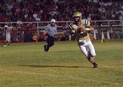 Image: Gladiator Q.B. Jase Holden(3) rolls out looking for a target as Panther quarterback Frank Morphis(14) watches from the Maypearl sideline.