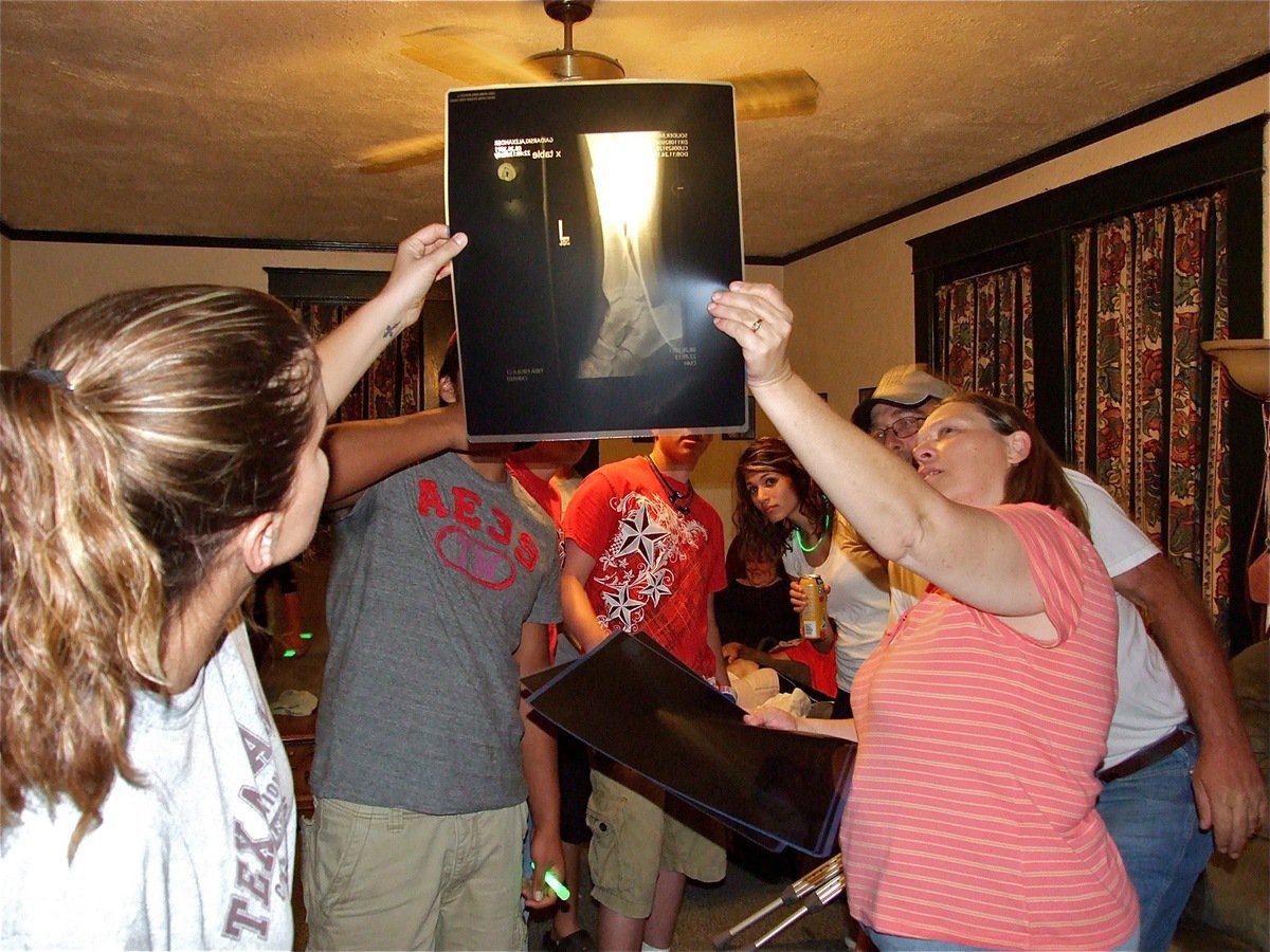 Image: Once inside, the family display Brandon’s x-rays of his leg.